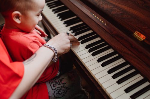 Rodzic i dziecko grają razem na pianinie